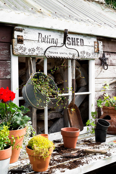 Potting Shed rake sign on a shed with Funky Junk's Old Sign Stencils. Paint professional looking vintage farmhouse styled garden signs onto reclaimed wood with a stencil in minutes!