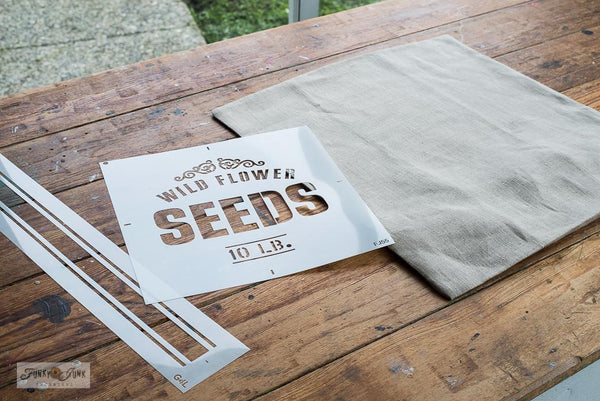 Make a vintage-inspired Wild Flower Seeds pillow with a 20" Ikea pillow cover, plus Wild Flower Seeds and Grain Sack Stripe G4L stencils from Funky Junk's Old Sign Stencils!