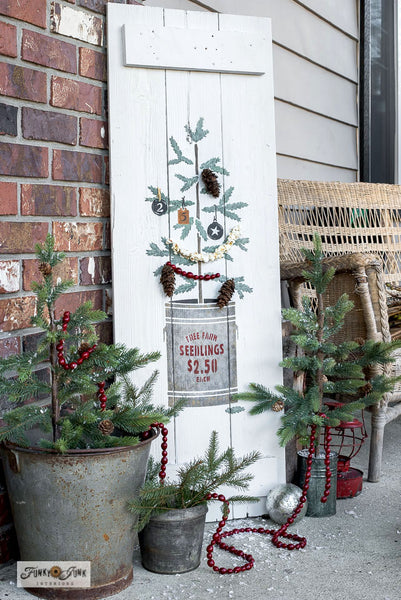 The Christmas Tree Seedling stencil features a Christmas tree seedling planted in a tin can, including a sign reading "Tree Farm Seedlings, 2.50 Each". This Christmas tree stencil features natural sparse branches attached to a woodsy stem, making decorating the tree so versatile! Makes the perfect Christmas porch sign!