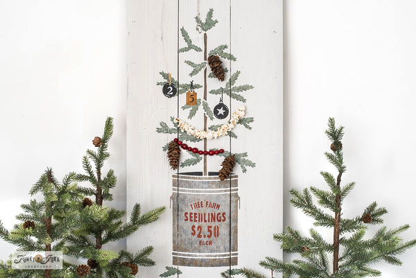 The Christmas Tree Seedling stencil features a Christmas tree seedling planted in a tin can, including a sign reading "Tree Farm Seedlings, 2.50 Each". This Christmas tree stencil features natural sparse branches attached to a woodsy stem, making decorating the tree so versatile! Makes the perfect Christmas porch sign!